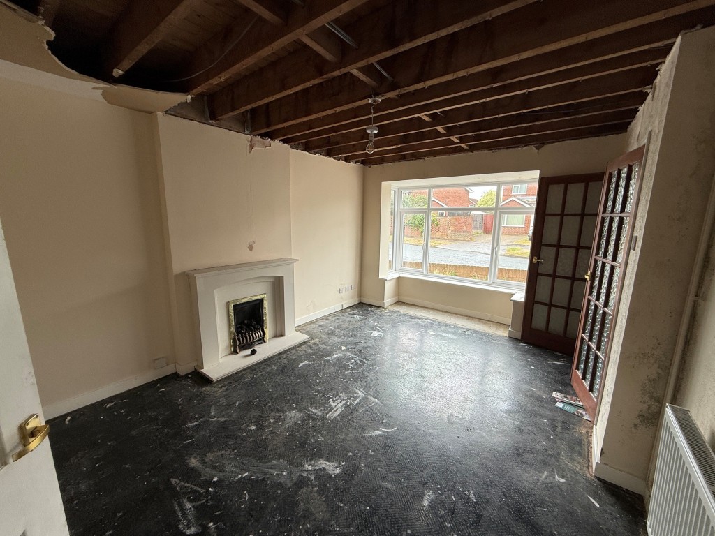 Lot: 114 - THREE-BEDROOM HOUSE FOR IMPROVEMENT AND REPAIR - Living room looking towards the front bay window